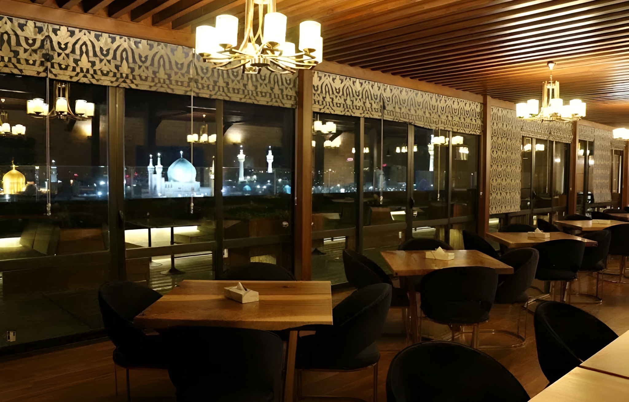 تصویر بخشی از کافی شاپ روف گاردن هتل رکسان در شب با ویوی حرم امام رضا