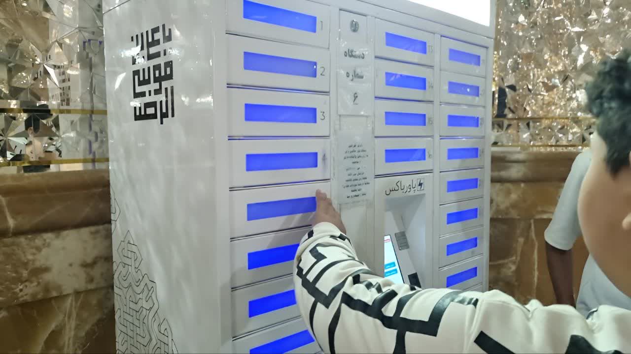 تصویر نوجوانی در حال باز کردن درب یکی از محل‌های شارژ پاورباکس حرم امام رضا (ع)